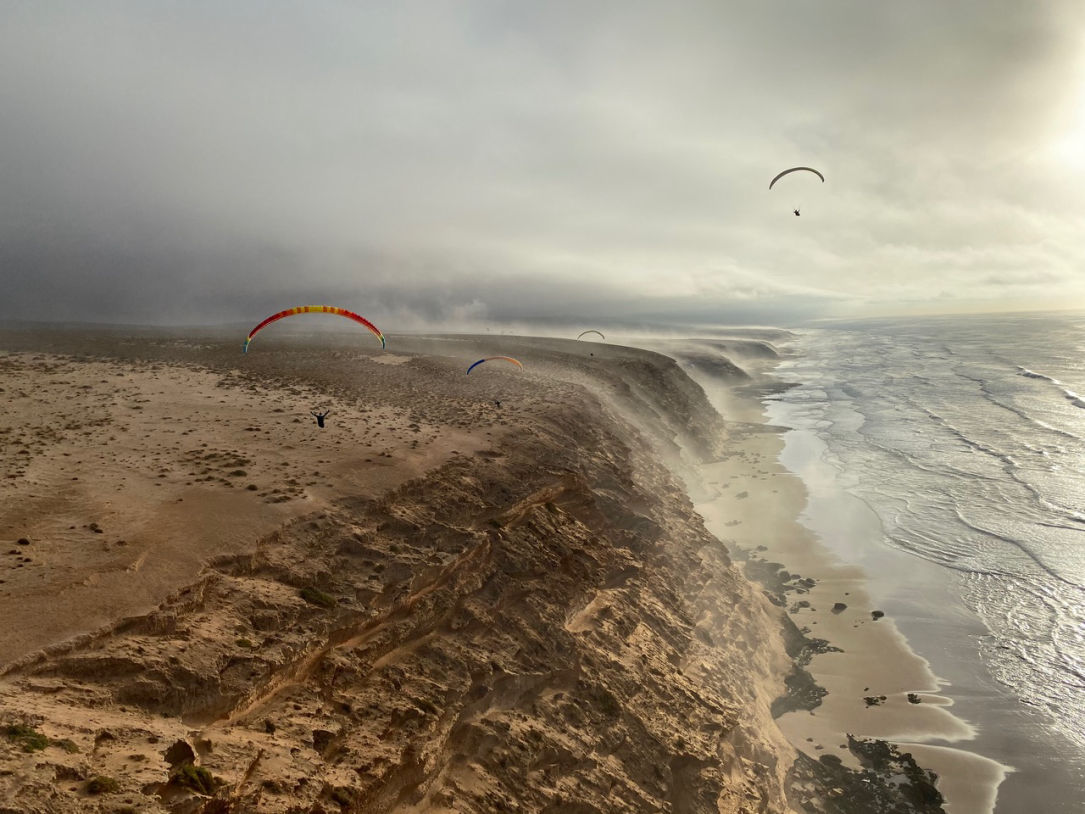Parapentes volant le long des falaises d'Aglou by Damien Lecire